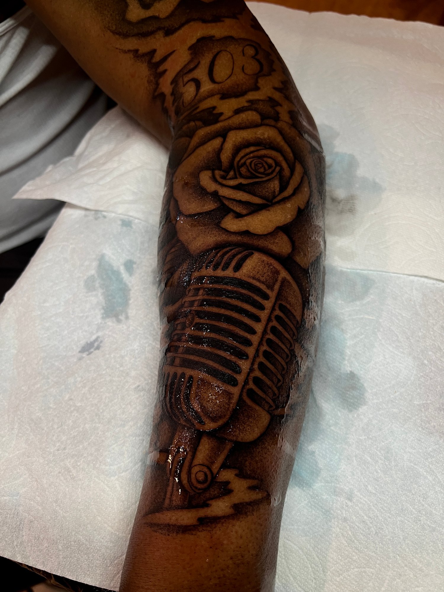 Fineline black and grey stippled tattoo of rose and microphone, Portland, Oregon